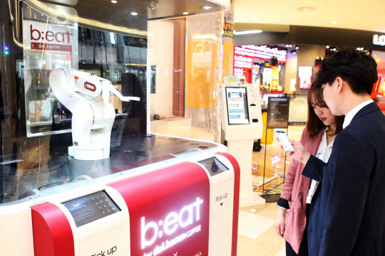 27일 서울 잠실 롯데월드몰 3층 로봇카페 '비트'에서 고객들이 앱으로 커피를 주문하고 있다. <롯데자산개발 제공>